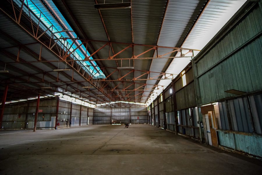 tall, big warehouse space with corrugated metal walls and ceiling support beams